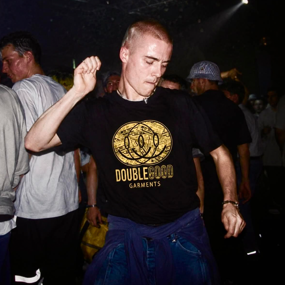 90s rave style man wearing Double Good Garments T-shirt at an Acid House warehouse rave
