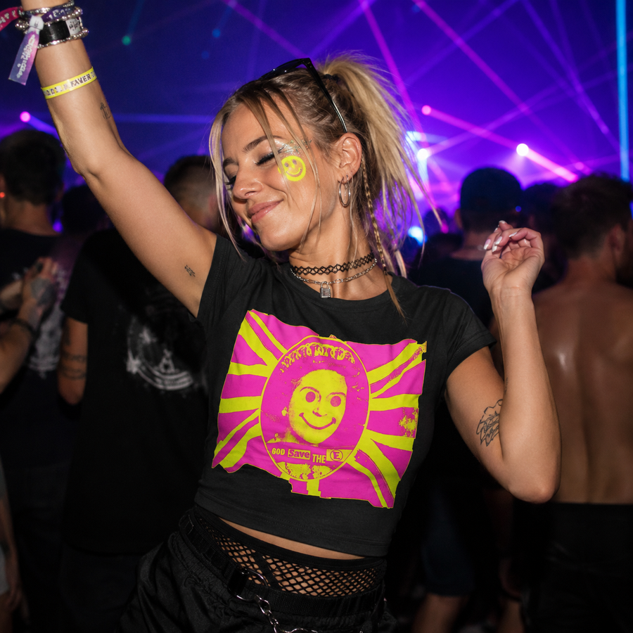 A woman dancing at a nightclub wearing a black crop top t-shirt with a bright pink and yellow graphic print of Double Good God Save the E.